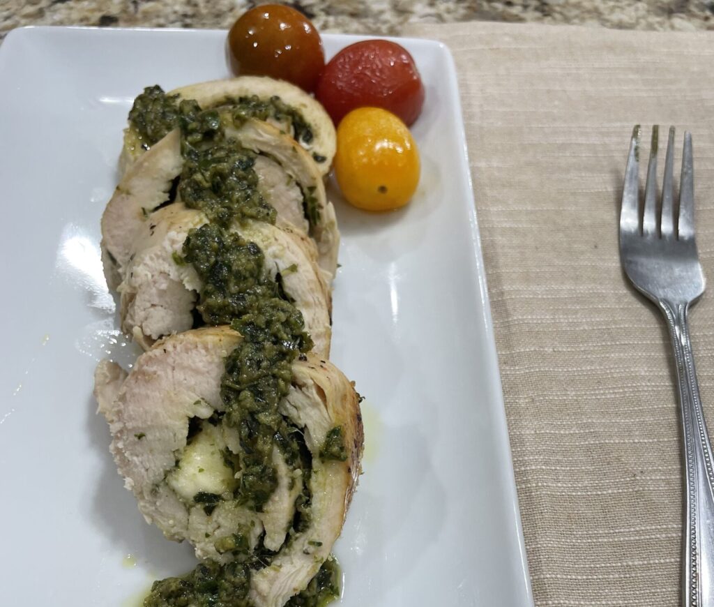 Sliced rouladen drizzled with pesto sauce