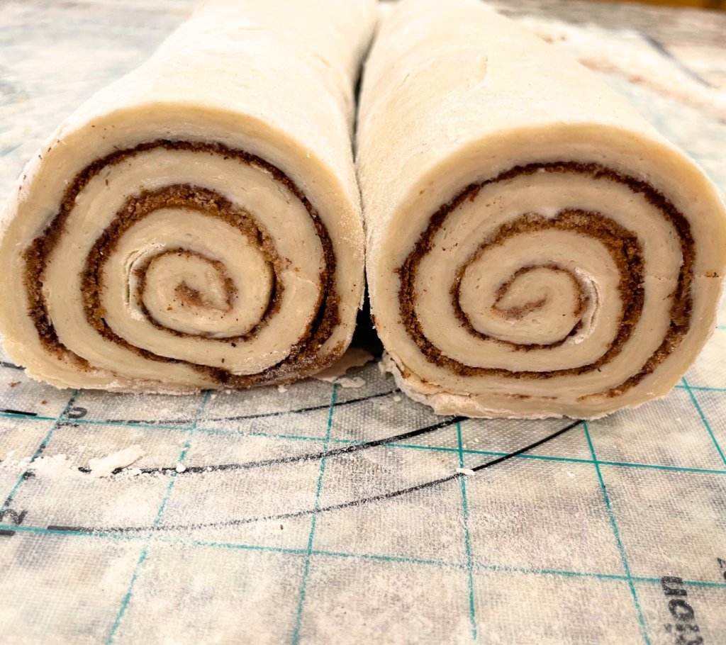 Side view picture of the two rolls of cinnamon rolls before they are sliced into individual cinnamon rolls. 