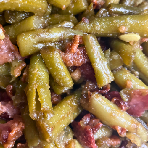 Close up of Crack Green beans with green beans and chopped up bacon.