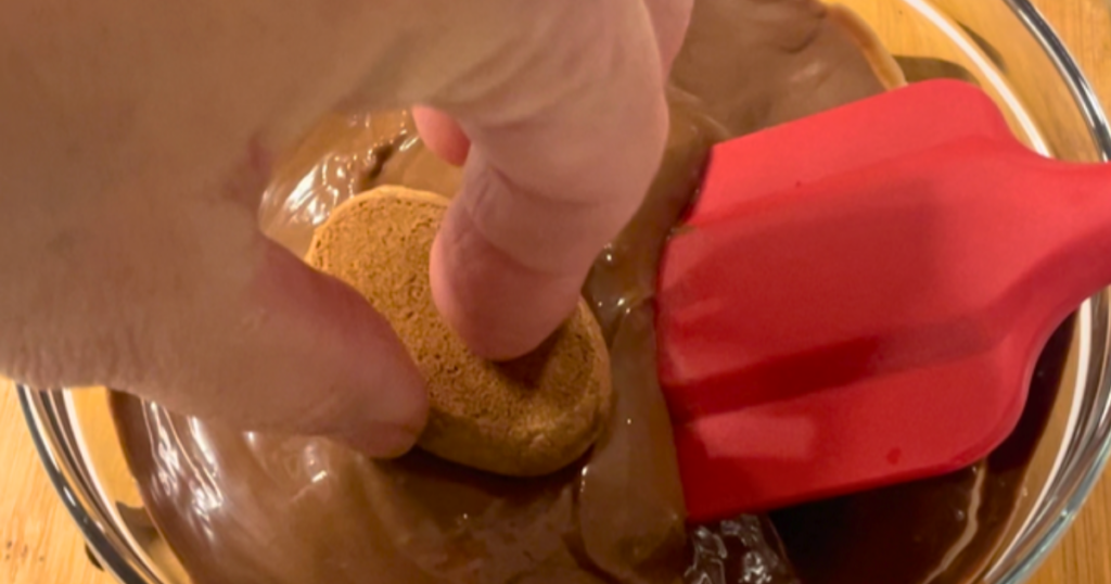 Dunking a cookie into a bowl of belted chocolate