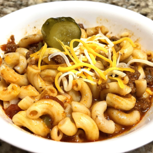 Bowl of goulash sprinkled with shredded cheese