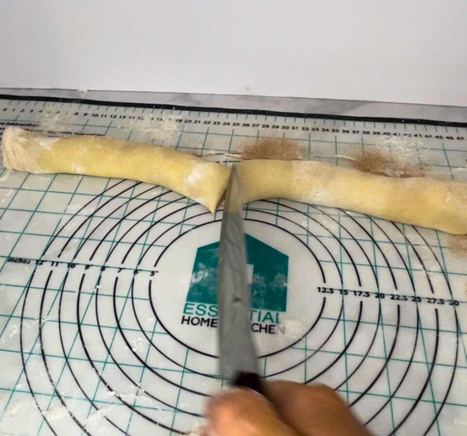 Cutting the dough log in half.